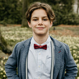 communicant met rood strikje en bretels