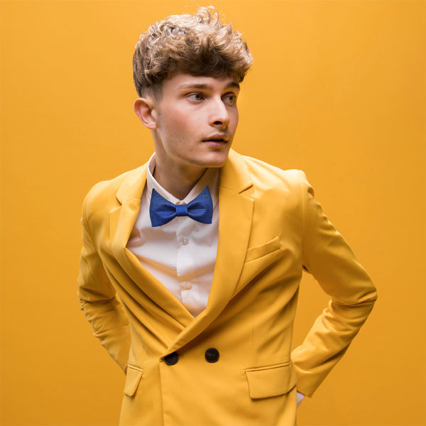 man wearing yellow suit and blue bow tie inspired by Joost Klein