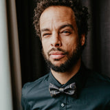 man in black shirt and black and gold bow tie