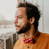 man with dark red cork bow tie