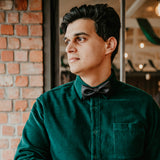 man wearing dark green shirt and black bow tie