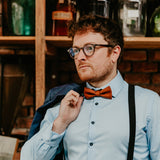 man wearing light blue shirt and cognac bow tie