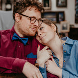 man with dark red shirt and blue bow tie