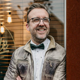 man wearing a dark green cork bow tie