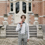 young boy in formal outfit with braces and bow tie