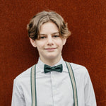 young boy wearing a dark green bow tie