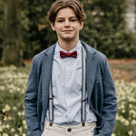 boy with dark red bow tie and suspenders