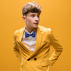 man wearing yellow suit and blue bow tie inspired by Joost Klein
