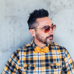 man wearing sunglasses, checkered shirt and cork bow tie
