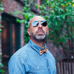 man in jeans with sunglasses and cork bow tie