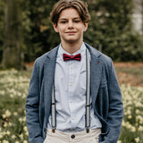 young boy wearing recycled jeans suspenders