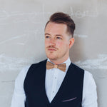 man with vest and wooden bow tie
